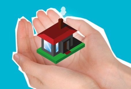 Budget Accommodation - Cutout paper composition with house in handful showing concept of buying private apartment against blue background