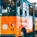 Wine-Tasting Tour - An orange and white bus is parked on the street